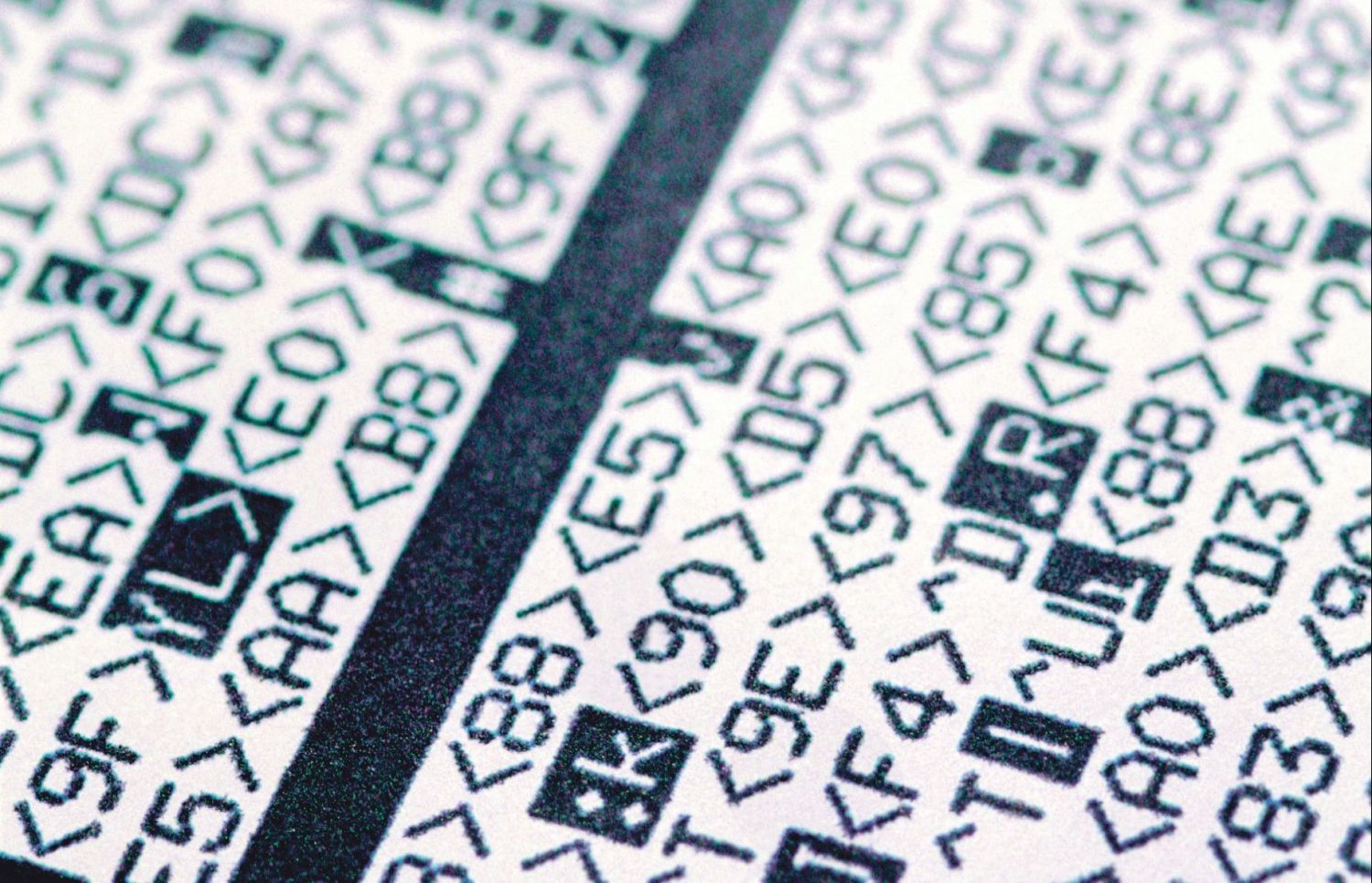  Detail eines mit Schrift- und Sonderzeichen bedruckten Papiers. Verschlüsselung ist in der Produktion ein wichtiges Thema